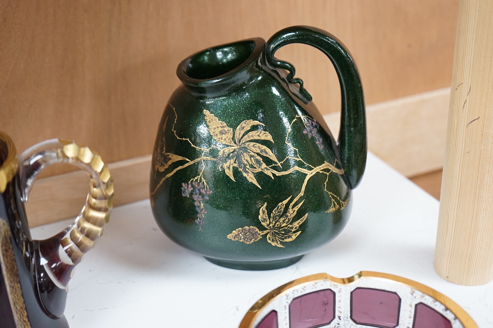 Three pieces of Bohemian and Austrian glassware comprising two jugs and an ashtray, largest 17cm high
